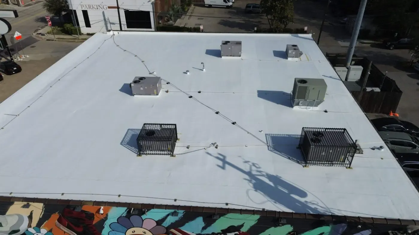 A drone’s eye view of a large commercial flat roof with a new TPO roof installed by Houston Roofing.