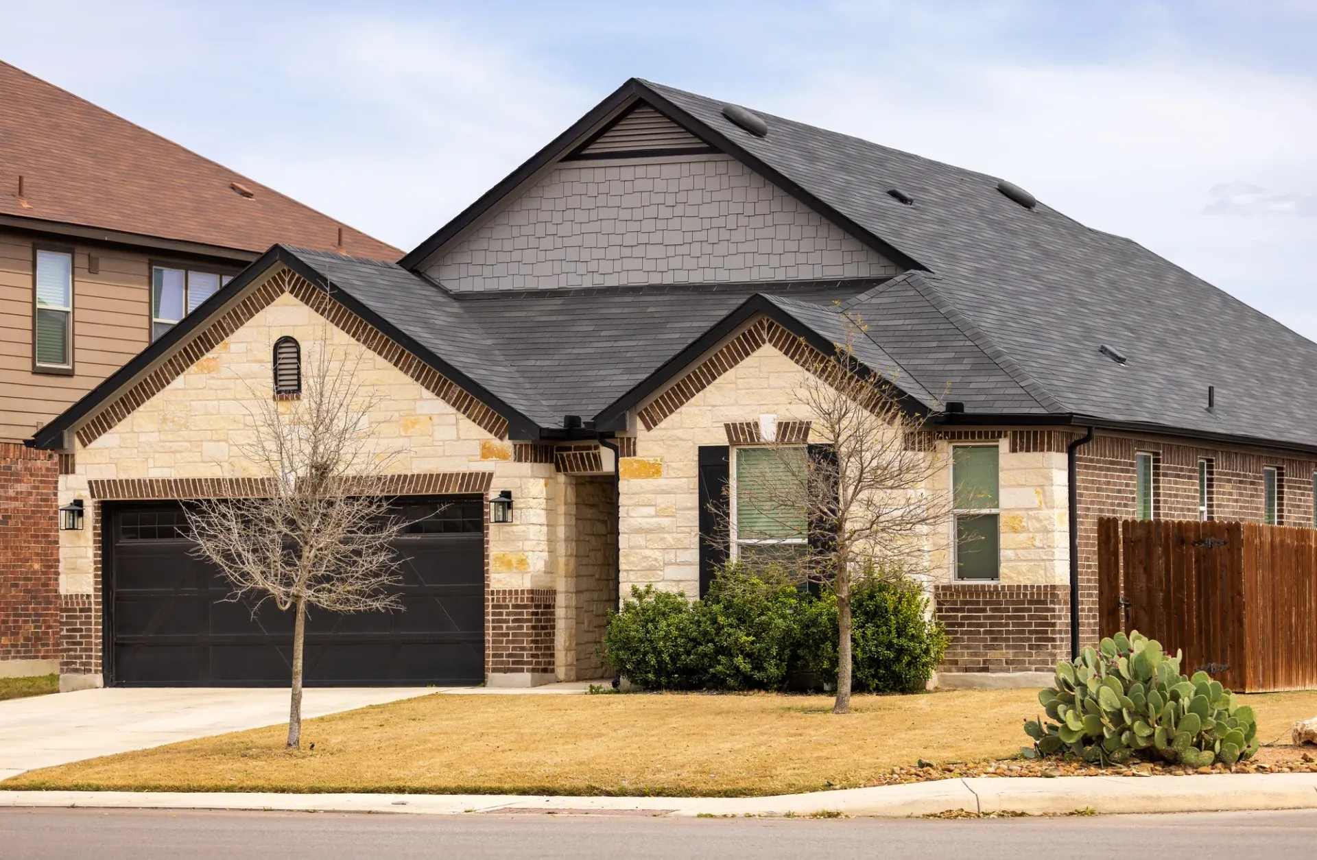 A beautiful brick house in Spring, TX sports a new dark gray roof